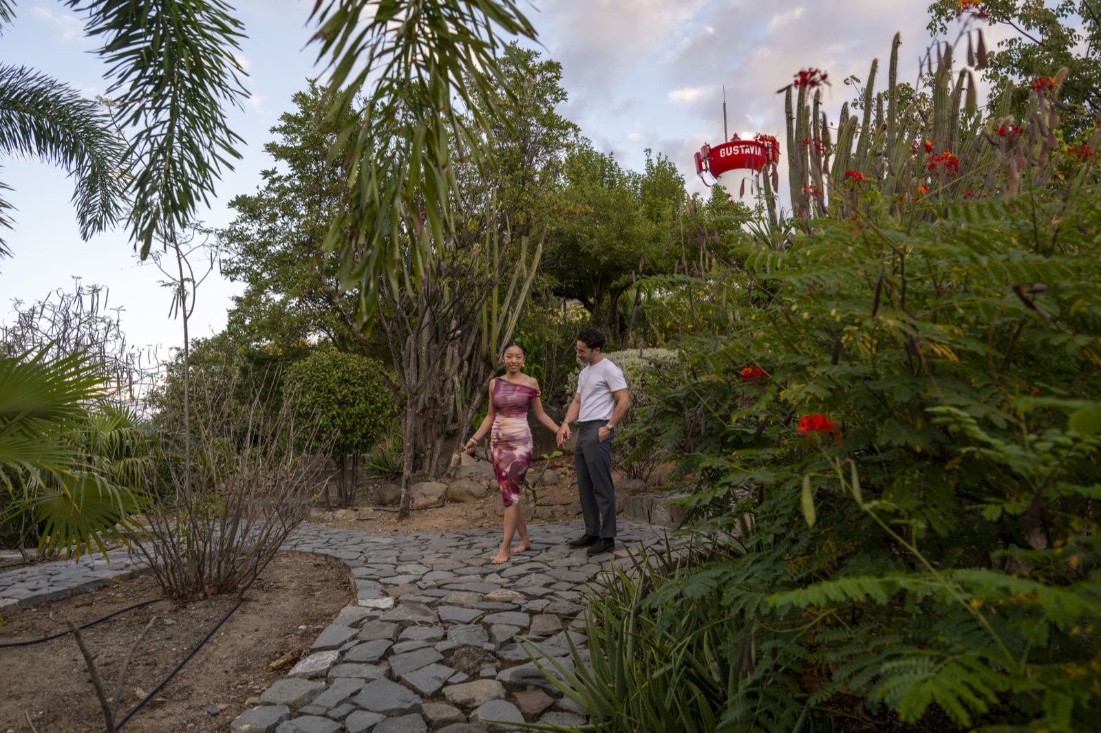 Fuanne and George walking hand-in-hand through a garden
